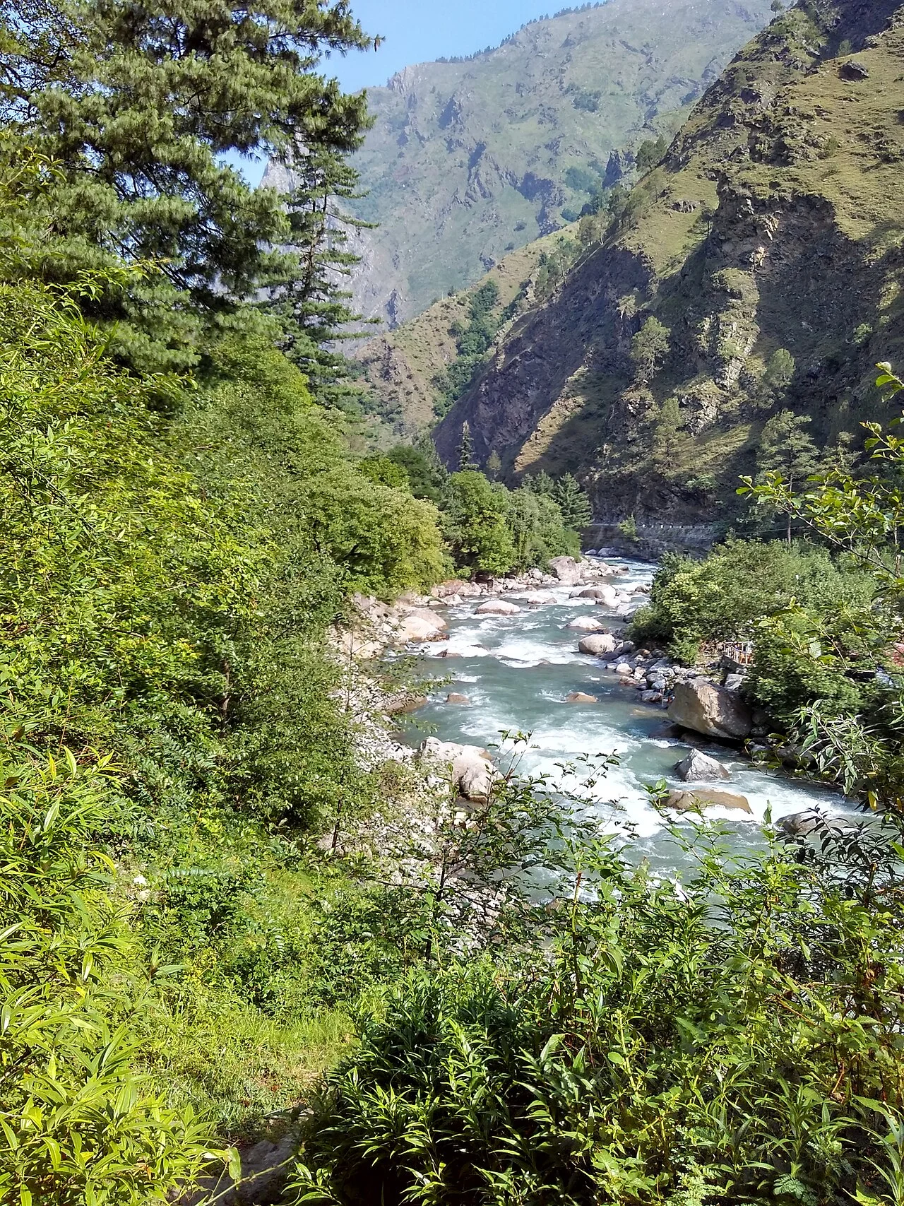 Clear turquoise waters of Tirthan river with boulder riverbed
